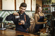 © Тарас Нагирняк - Cute couple, male and female barista working in coffee shop counter. Barista working at cafe