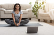 © Prostock-studio - Domestic Yoga. Smiling African Woman Meditating At Home In Front Of Laptop