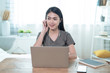 © Basicdog - Young Asian woman who loves music, sits at work and listens to music on a casual day in her home, Working at home.