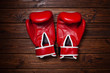 Red boxing gloves on wooden background