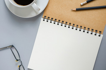 Wall Mural - top view. blank open spiral notebook, pencils, glasses and a cup of coffee in working time mood. emp
