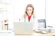© Masato - Female beautiful wearing a doctor uniform using a notebook computer and talking case of treatment.