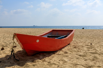 Wall Mural - Tropical landscape. Red wooden boat on a sandy beach.