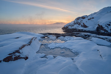 Winter arctic landscape in the morning on the Barents Sea with fog from frost