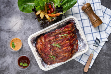 Wall Mural - Grilled pork ribs with Vegetables and sauces on a drak table