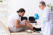 © Elnur - Leg injured man visiting old doctor in first aid concept
