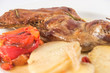 Baked leg of goat, with baked potatoes and roasted red peppers.