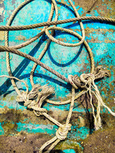 Fishman Ship Rope Knots And Turquios Blue Wooden Background. Aquamarine And Knitted Knots.