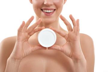 I love this cream. Young attractive woman demonstrating cosmetic product and smiling at camera while standing against white background.