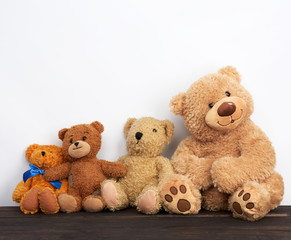 Wall Mural - various brown teddy bears are sitting on a brown wooden table