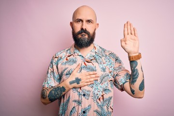 Sticker - Handsome bald man with beard and tattoo wearing casual floral shirt over pink background Swearing with hand on chest and open palm, making a loyalty promise oath