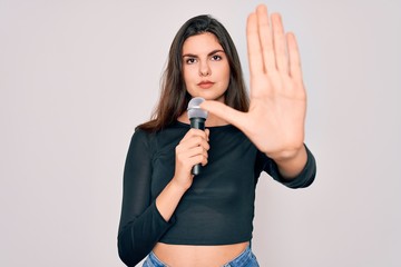 Sticker - Young beautiful singer performer girl singing using music microphone over isolated background with open hand doing stop sign with serious and confident expression, defense gesture