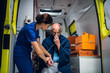© Anna Kosolapova - An injured, shocked man sitting with an oxygen mask in an ambulance, woman in a medical uniform is checking his pulse