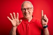 © Krakenimages.com - Grey haired senior man wearing glasses and casual t-shirt over red background showing and pointing up with fingers number six while smiling confident and happy.