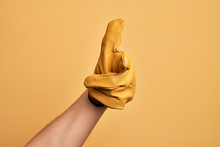Hand Of Caucasian Young Man With Gardener Glove Over Isolated Yellow Background Pointing Forefinger To The Camera, Choosing And Indicating Towards Direction