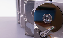 Close Up Of An Open Hard Drive Stacked Up With Other Hard Drives.