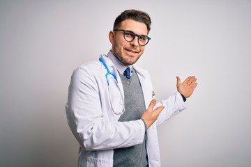 Wall Mural - Young doctor man with blue eyes wearing medical coat and stethoscope over isolated background Inviting to enter smiling natural with open hand