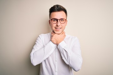 Wall Mural - Young handsome business mas wearing glasses and elegant shirt over isolated background shouting and suffocate because painful strangle. Health problem. Asphyxiate and suicide concept.