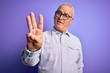 © Krakenimages.com - Middle age handsome hoary man wearing striped shirt and glasses over purple background showing and pointing up with fingers number three while smiling confident and happy.