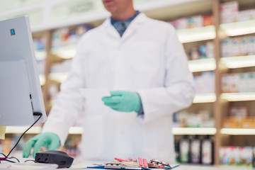 Wall Mural - Male pharmacist working at pharmacy. Medical healthcare concept.