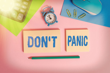 Handwriting text Don T Panic. Conceptual photo suddenly feel so worried or frightened that you can not behave Wire mouse clock calculator notepads marker sheets clips color background