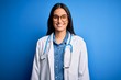 © Krakenimages.com - Young beautiful doctor woman wearing stethoscope and glasses over blue background with a happy and cool smile on face. Lucky person.