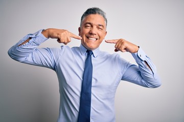 Poster - Middle age handsome grey-haired business man wearing elegant shirt and tie smiling cheerful showing and pointing with fingers teeth and mouth. Dental health concept.