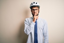 Young Businessman Wearing Glasses And Bike Helmet Standing Over Isolated White Bakground Asking To Be Quiet With Finger On Lips. Silence And Secret Concept.