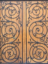 Full Frame Shot Of Wooden Door With Ornate Wrought Iron Pattern