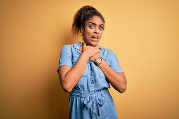 Sticker - Young beautiful african american girl wearing denim dress standing over yellow background shouting suffocate because painful strangle. Health problem. Asphyxiate and suicide concept.