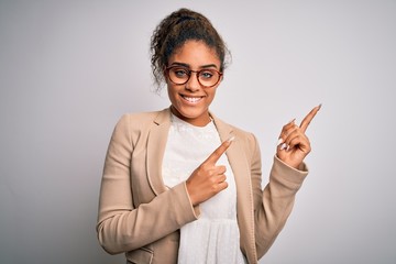 Poster - Beautiful african american businesswoman wearing jacket and glasses over white background smiling and looking at the camera pointing with two hands and fingers to the side.