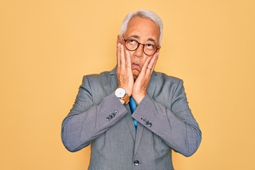 Wall Mural - Middle age senior grey-haired handsome business man wearing glasses over yellow background Tired hands covering face, depression and sadness, upset and irritated for problem