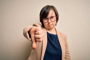 Sticker - Young down syndrome business woman wearing glasses standing over isolated background looking unhappy and angry showing rejection and negative with thumbs down gesture. Bad expression.