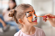 © Pixel-Shot - Woman painting face of little girl at home