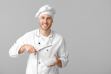 Canvas Print - Male confectioner cooking tasty dessert on grey background