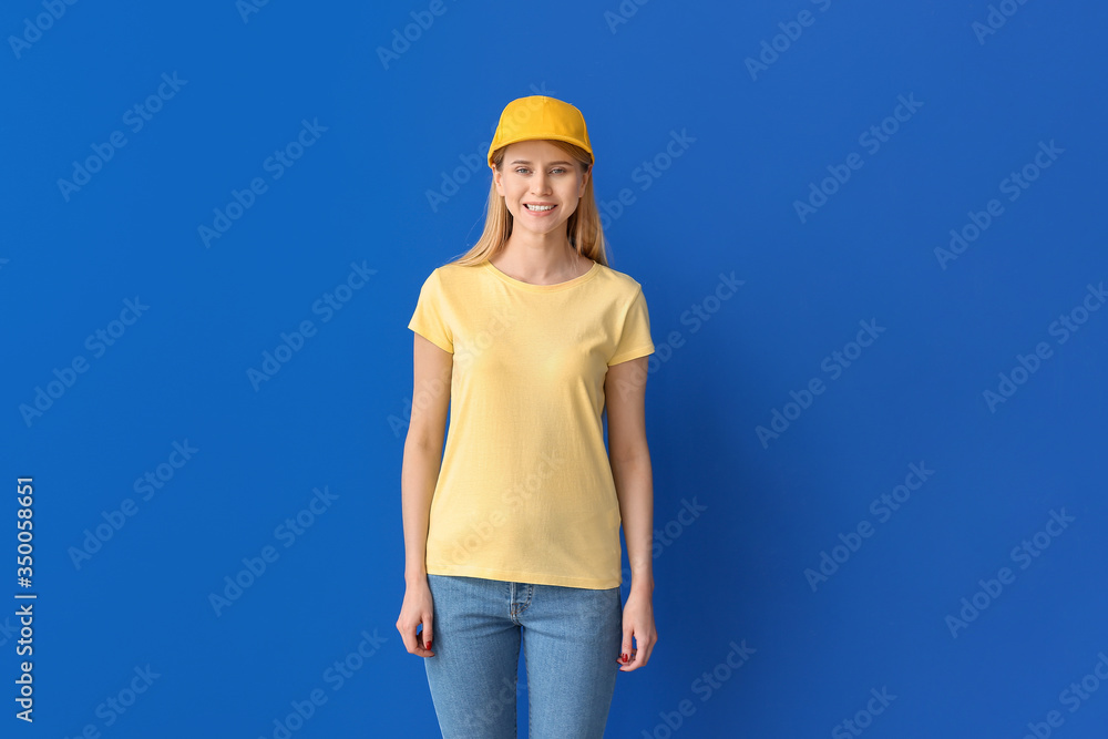 Beautiful young woman in stylish cap on color background