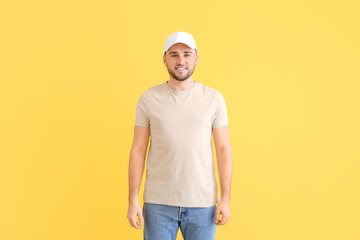 Wall Mural - Handsome man in stylish cap on color background