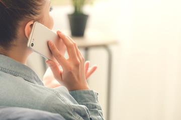 Woman talking by mobile phone at home