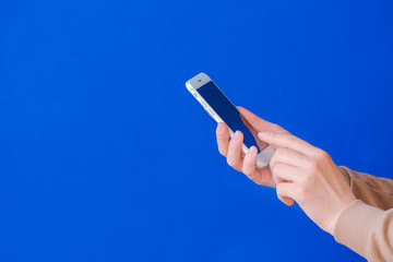 Woman with mobile phone on color background