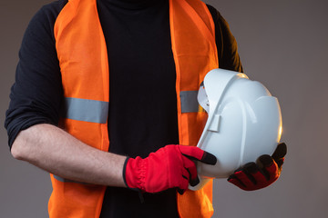 A man in work clothes. A man in a reflective vest and work glove