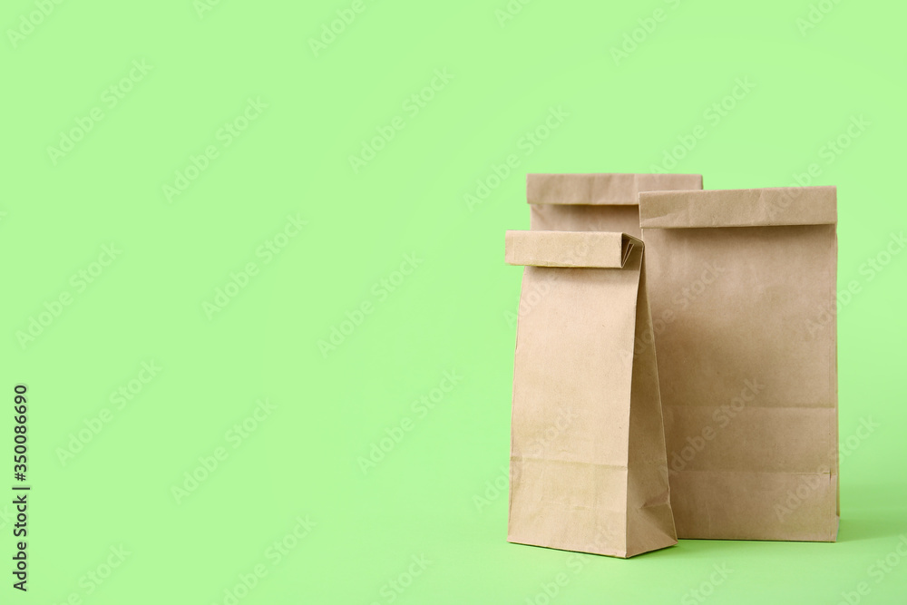Paper bags on color background