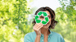 © Syda Productions - eco living, environment and sustainability concept - portrait of happy smiling young woman in turquoise shirt looking through recycling sign over green natural background