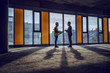 © Dusan Petkovic - Silhouette of construction worker and architect standing near window in future business center and talking about realization of the project.