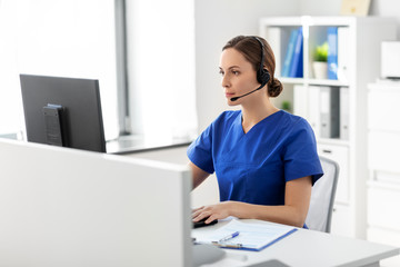 Wall Mural - medicine, technology and healthcare concept - female doctor or nurse with headset and computer working at hospital