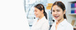 © sitthiphong - Smiling Asian businesswoman consultant wearing microphone headset of customer support phone operator at workplace.