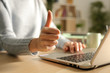 © PheelingsMedia - Woman hands with thumbs up using laptop at night