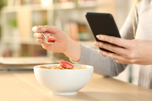 Woman Hands Eating Cereal Bowl Checking Phone At Home
