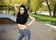 © Вячеслав Чичаев - The model stands against the backdrop of a city park in fine weather. Photo in spring weather outdoors, a caucasian brunette girl with a slim figure is posing with pleasure.
