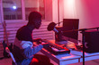 © satura_ - Professional african american musician recording synthesizer in digital studio at home, Music production technology concept.