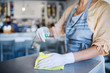 © Halfpoint - Unrecognizable woman working with gloves in coffee shop, disinfecting tables.